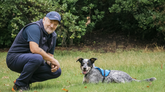 Bobby the conservation dog and his handler Brian, sitting side by side.